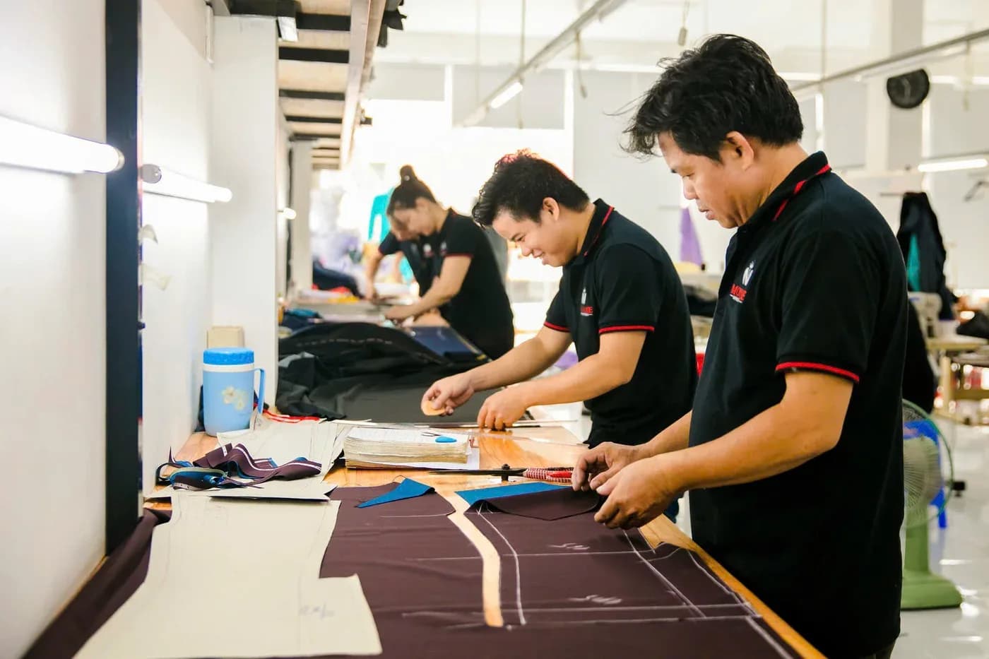 Tổ cắt trải vải tím than lên bàn cắt