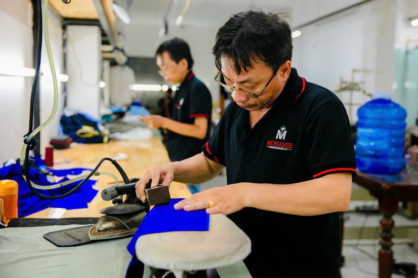 Thợ ủi định hình thân vải xanh cobalt