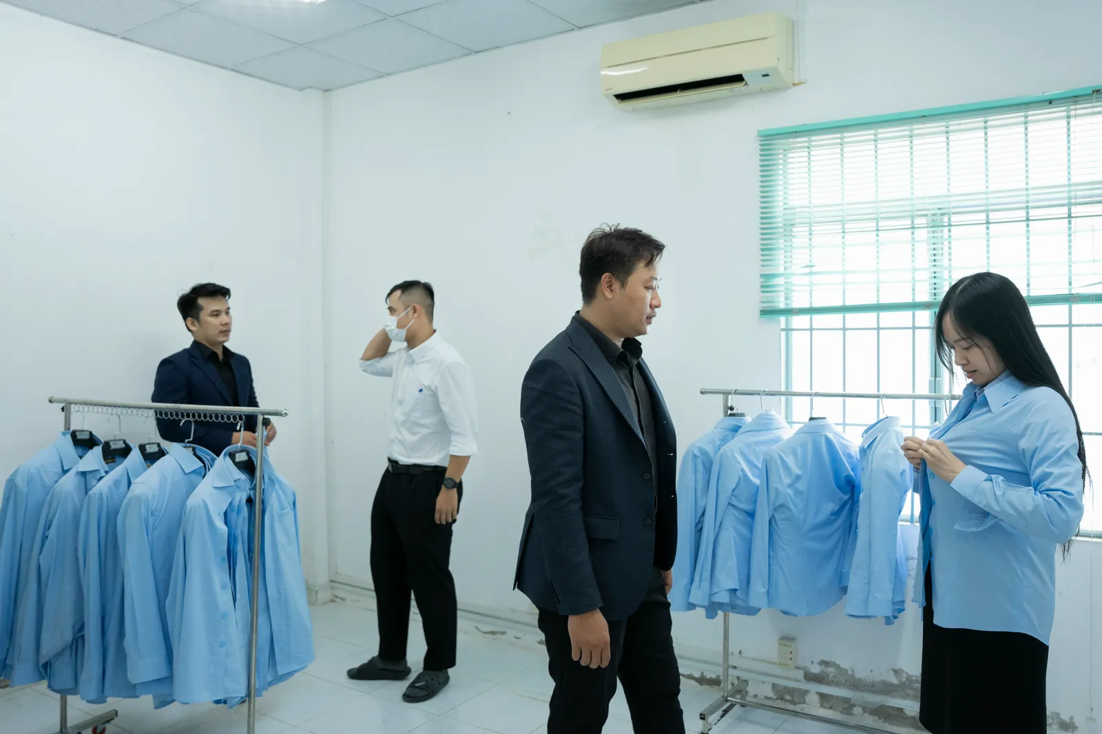 Thu Duc Water Supply staff trying sample shirts from the rail